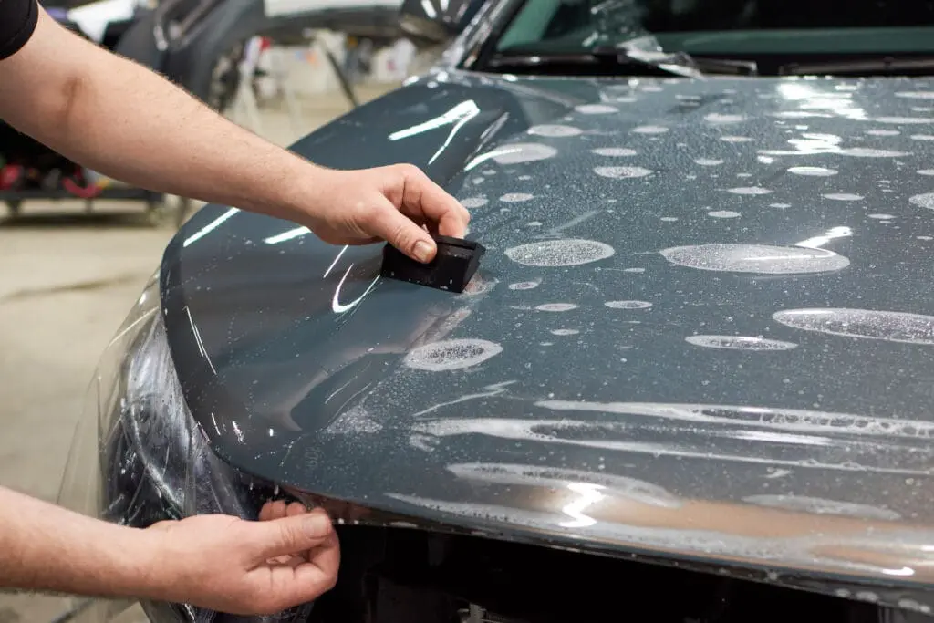 Applying a removable protective coating to a car hood